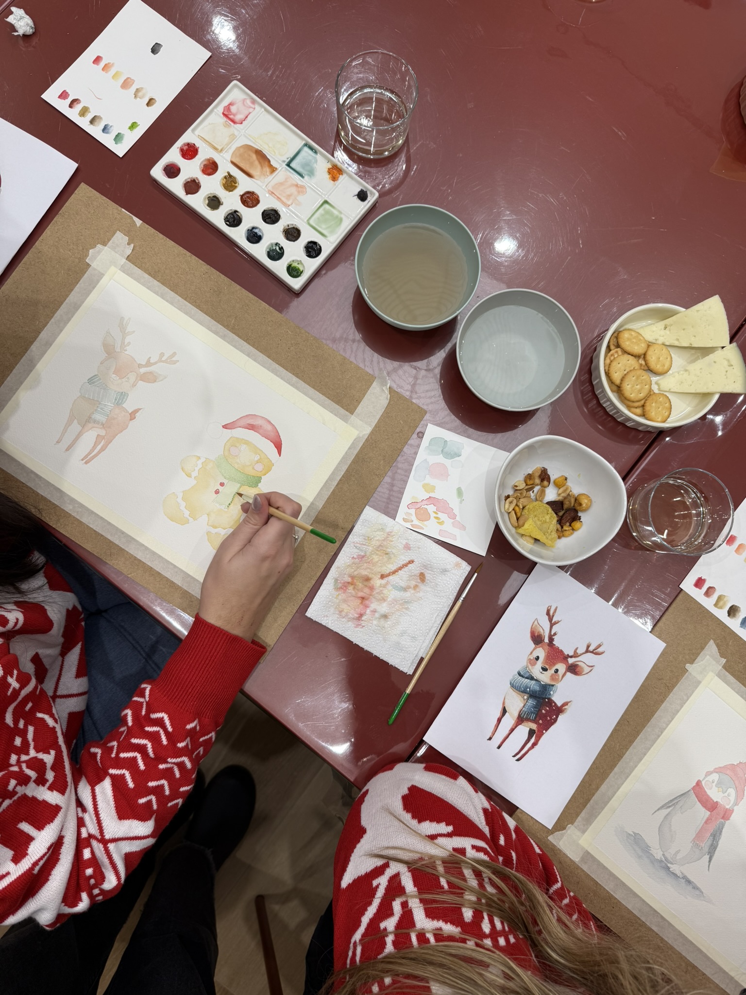 Mesa con acuarelas, vino y aperitivo durante una experiencia creativa
