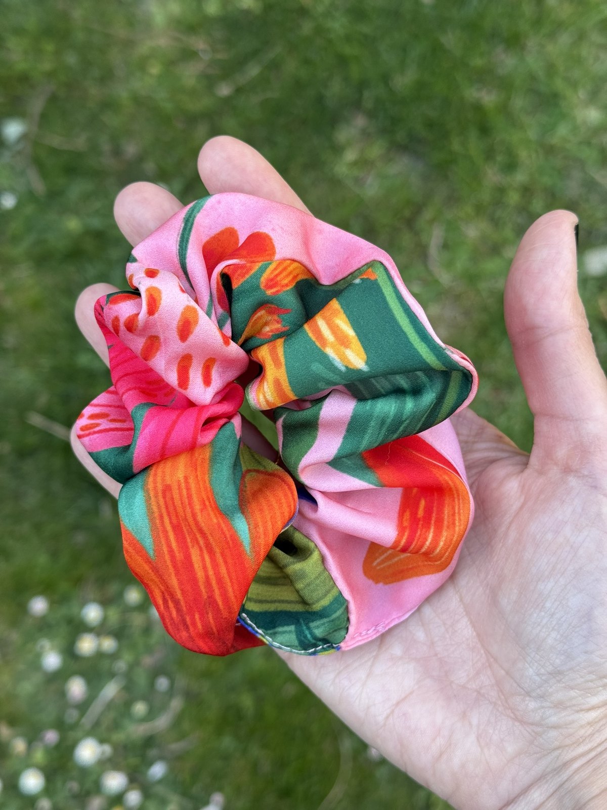 Coletero de tela ilustrada con estampado floral en tonos rosa, verde y naranja