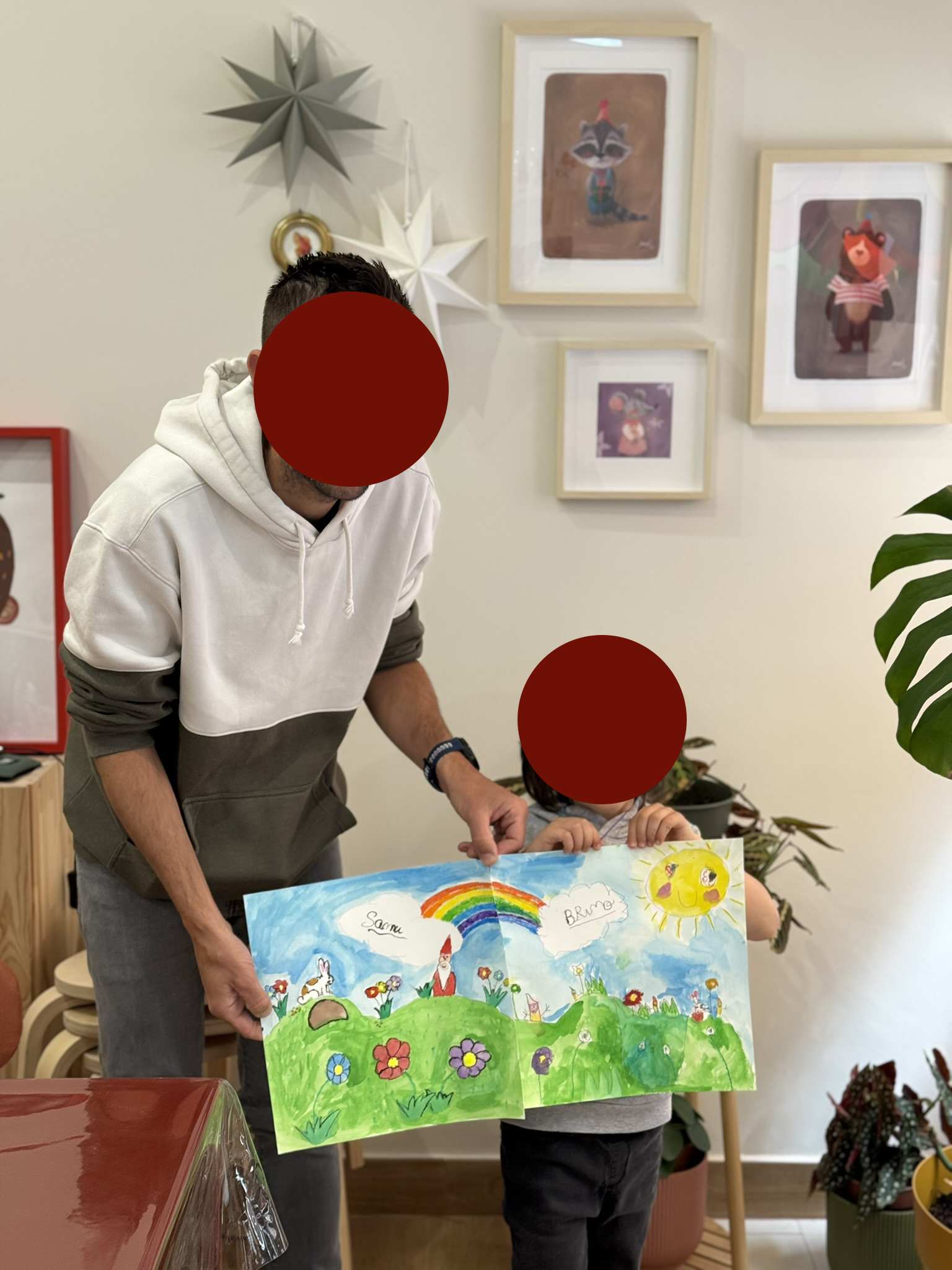 Adulto y niño mostrando un mural realizado en un taller familiar